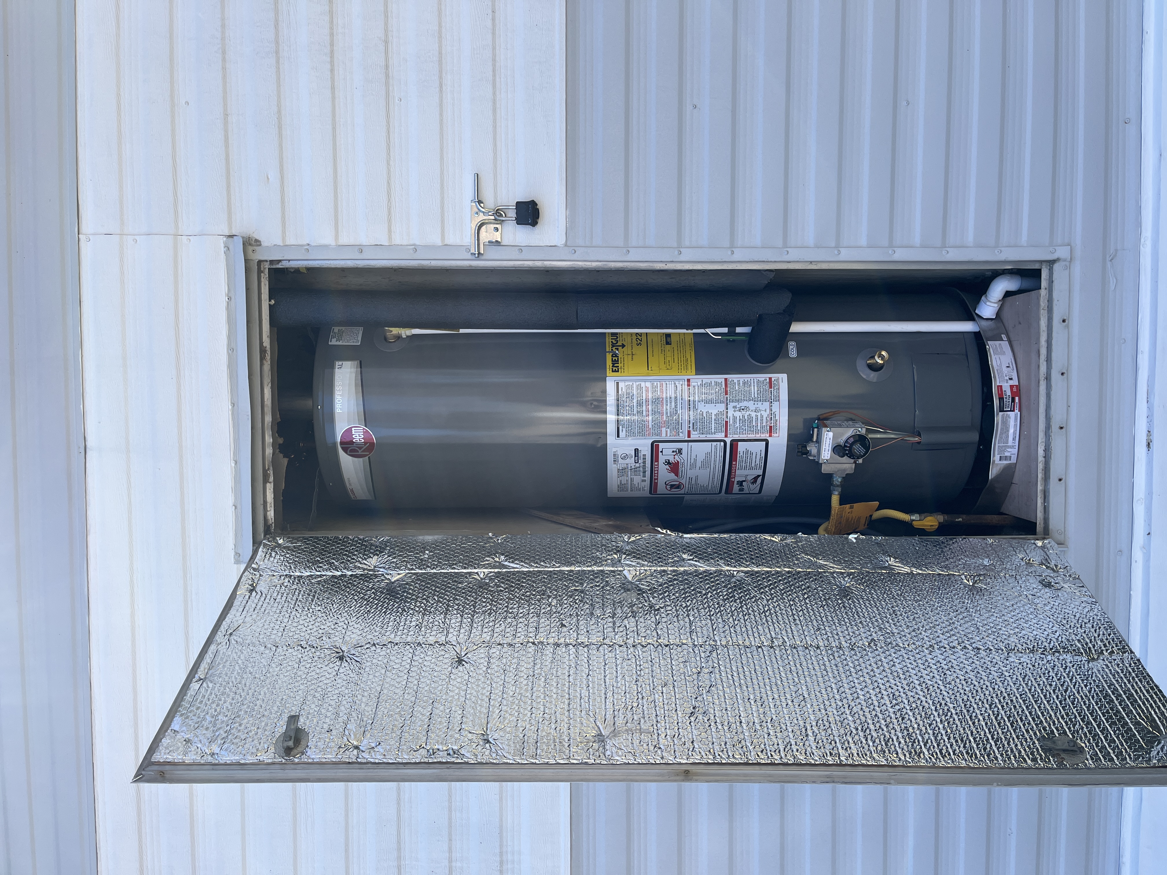 A newly installed Rheem 40 gallon direct vent atmospheric water heater in a Holland mobile home exterior utility closet, matching the review from Maria Fraga.